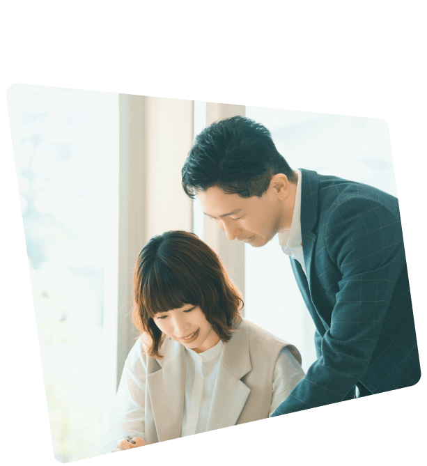 明るいオフィスで女性と男性の2人のビジネスパーソンが協力して話し合い、チームワークを表現した様子